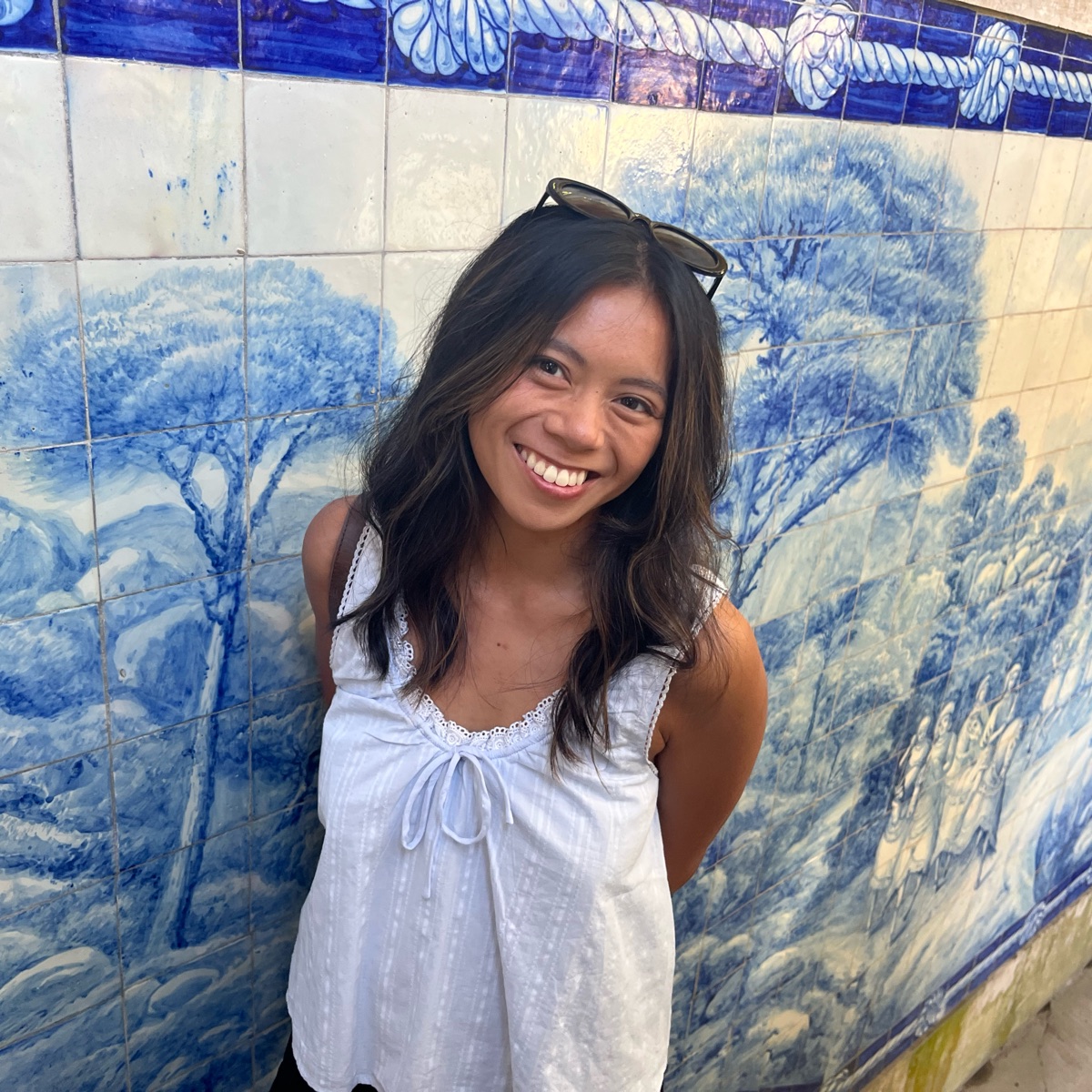 Allison smiling in front of a blue and white tiled wall